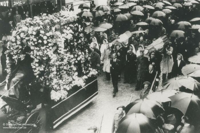 Funeral procession, people walking behind the coffin