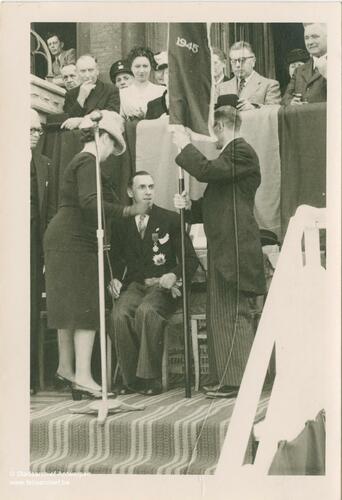 Marcel Louette sitting on a chair with a microphone with two people opposite him