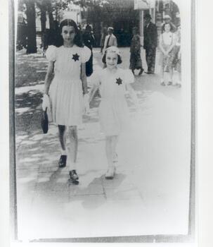 Two Jewish girls walking hand in hand in De Keyserlei with the Star of David on their dresses