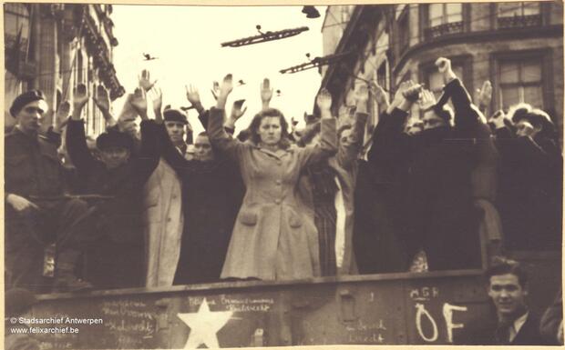 A group of people standing with their hands up