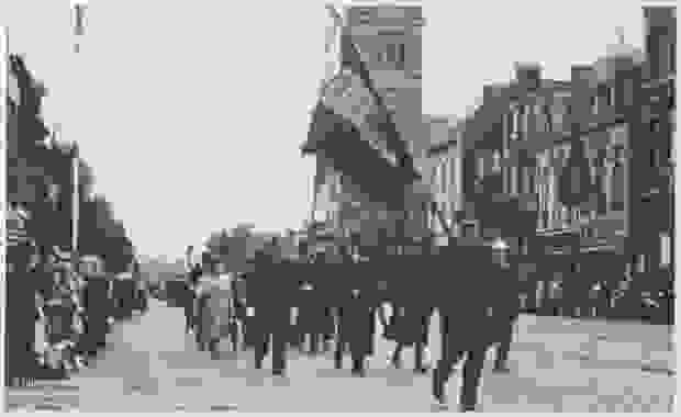 A soldier with a flag accompanies Canadian army units on the street