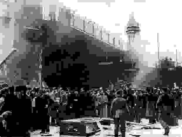 A crowd stands around a synagogue that is set on fire